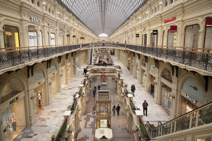 FILE - Few visitors walk inside the GUM department store in Moscow, in Moscow, Russia, Friday, March 4, 2022. Three months after the Feb. 24 invasion, many ordinary Russians are reeling from those blows to their livelihoods and emotions. Moscow's vast shopping malls have turned into eerie expanses of shuttered storefronts once occupied by Western retailers. (AP Photo, File)