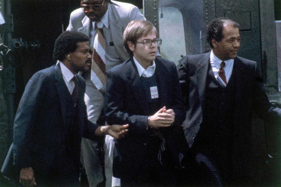 Mandatory Credit: Photo by Barry Thumma/AP/Shutterstock (12471536a) U.S. Marshalls escort John Hinckley Jr. as he returns to a marine base via helicopter in Quantico, Va. on Aug. 8, 1981. Lawyers are scheduled to meet in federal court on to discuss whether Hinckley Jr., the man who tried to assassinate President Ronald Reagan, should be freed from court-imposed restrictions including overseeing his medical care and keeping up with his computer passwords John Hinckley Jr, Quantico, United States - 27 Sep 2021