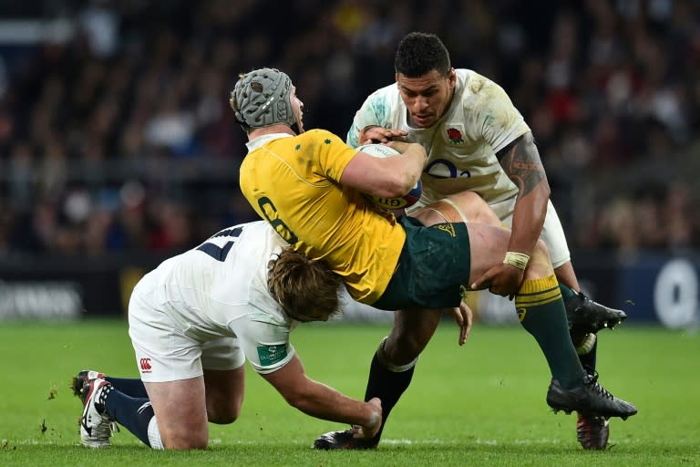 Australia's David Pocock (centre) is tackled by England's Joe Marler (left) and Nathan Hughes during the Test match at Twickenham stadium in south-west London, on December 3, 2016