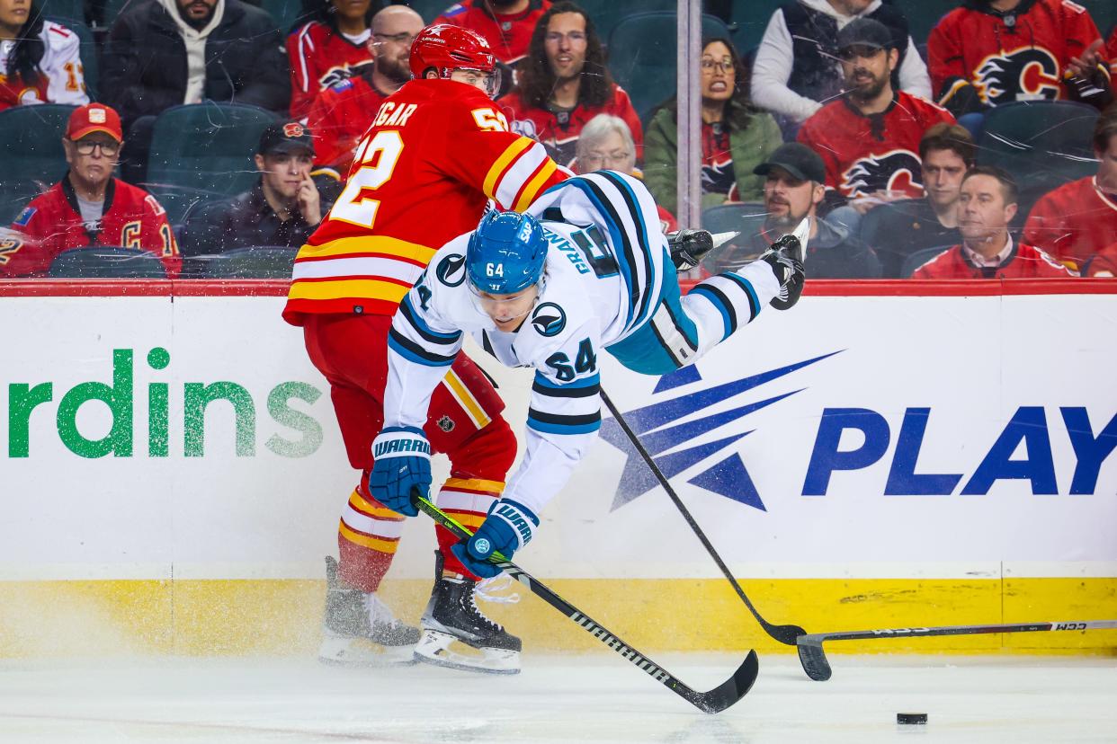 Calgary Flames defenseman MacKenzie Weegar (52) and San Jose Sharks center Mikael Granlund (64) collide as they battle for the puck during the season finale.