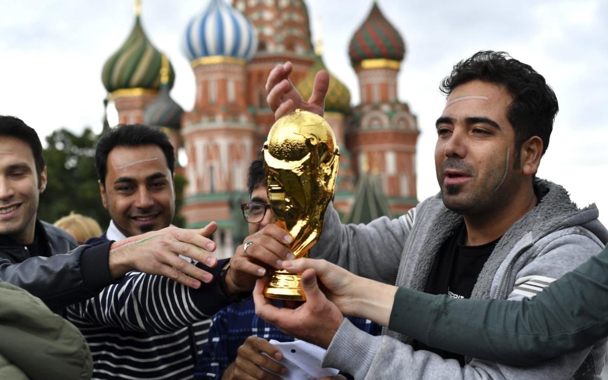 Iranian fans hold a replica trophy on Red Square ahead of the World Cup, which starts Thursday - AFP