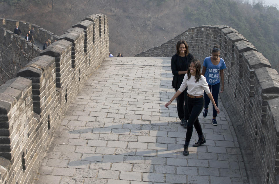 First lady Michelle Obama shares a light moment with her daughters Malia and Sasha as they visit the Mutianyu section of the Great Wall of China in Beijing, Sunday, March 23, 2014.