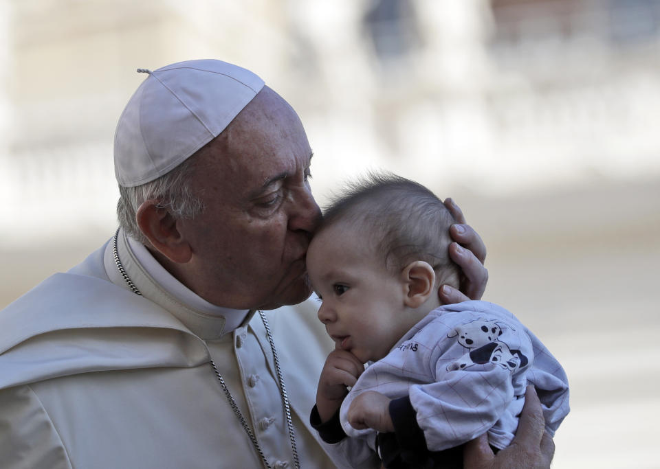 Pope Francis kisses a baby as he arrives in St. Peter's Square at the Vatican for his weekly general audience, Wednesday, Sept. 12, 2018. (AP Photo/Alessandra Tarantino)