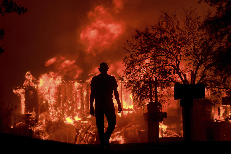 <p>Jim Stites watches part of his neighborhood burn in Fountaingrove, Calif., Monday Oct. 9, 2017. More than a dozen wildfires whipped by powerful winds been burning though California wine country. The flames have destroyed at least 2,000 homes and businesses and sent thousands of people fleeing. (Photo: Kent Porter/The Press Democrat via AP) </p>