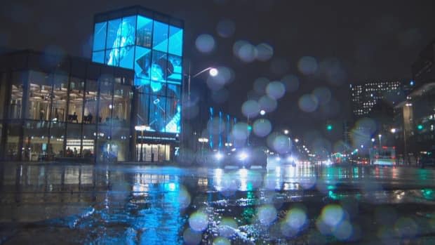 Nighttime rain falls near the National Arts Centre in Ottawa as most of our area is under a rainfall warning. Ontario's vaccine passport system begins and the NAC is included. (CBC - image credit)