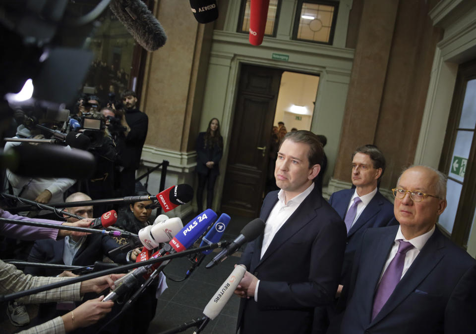 Former Austrian Chancellor Sebastian Kurz talks to the media as he stands in front of his lawyers Otto Dietrich, center, and Walter Suppan, right, before appearing at court on the first day of his trial in Vienna, Austria, Wednesday, Oct. 18, 2023. Kurz is charged with having allegedly making false statements to a parliamentary inquiry into alleged corruption in his first government. (AP Photo/Heinz-Peter Bader)