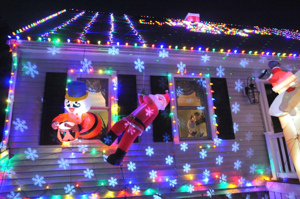 Projected images of snowflakes grace the front of the Holiday House of Hanson at 16 Woodbrook Lane.