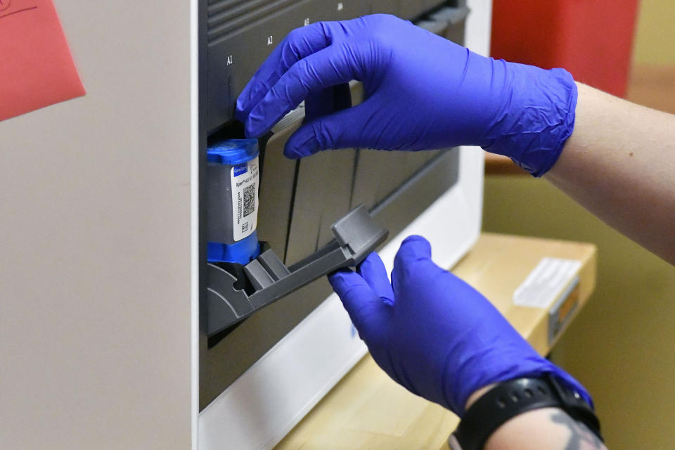 Ashley Holliday, senior medical assistant, loads a sample to test for hepatitis C and HIV in Hazard, Ky., Monday, Dec. 12, 2022. Results for both are completed within 20 minutes. A study underway in the hard-hit corner of the state is exploring a simple way to get more people treated for hepatitis C. (AP Photo/Timothy D. Easley)