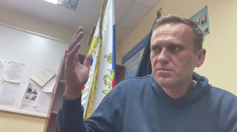 Russian opposition leader Alexei Navalny speaks as he waits for a court hearing in a police station in Khimki