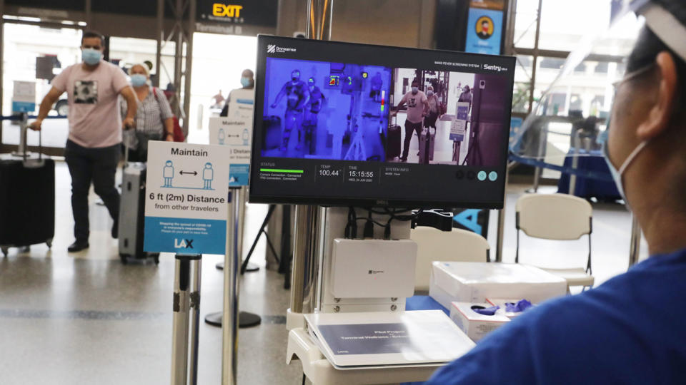 Travelers walks past a test system of thermal imaging cameras which check body temperatures at Los Angeles International Airport (LAX) amid the COVID-19 pandemic on June 24, 2020 in Los Angeles, California. (Mario Tama/Getty Images)