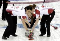 Canada's vice Kaitlyn Lawes (C) delivers a stone as teammates Jill Officer (L) and lead Dawn McEwen sweep the ice during their women's curling semifinal game against Britain at the 2014 Sochi Winter Olympics in the Ice Cube Curling Center in Sochi February 19, 2014. REUTERS/Ints Kalnins (RUSSIA - Tags: SPORT OLYMPICS SPORT CURLING)