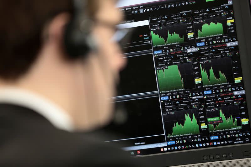 FILE PHOTO: A broker looks at financial information on computer screens on the IG Index the trading floor