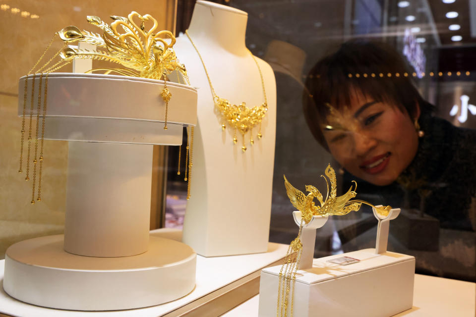 2023年12月4日，在浙江省湖州市德清縣乾元鎮一家黃金店，顧客在挑選黃金首飾。（圖／新華社）