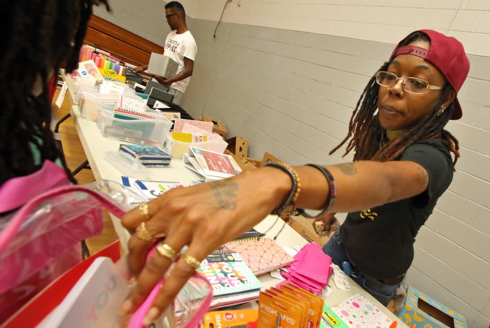 Shanise Davis helps students with school supplies during the Backpack to School Backpack Giveaway event held Saturday, Aug. 12, 2023, at the Erwin Center in Gastonia.
