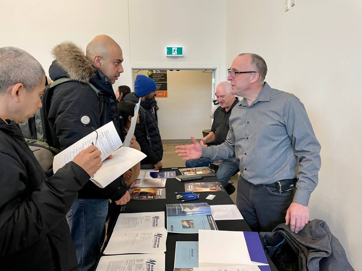 Bert Sonier, vice-president of operations for Maritime Hydraulic, speaks with job-seekers at a newcomer employment fair in Moncton. (Alexandre Silberman/CBC - image credit)