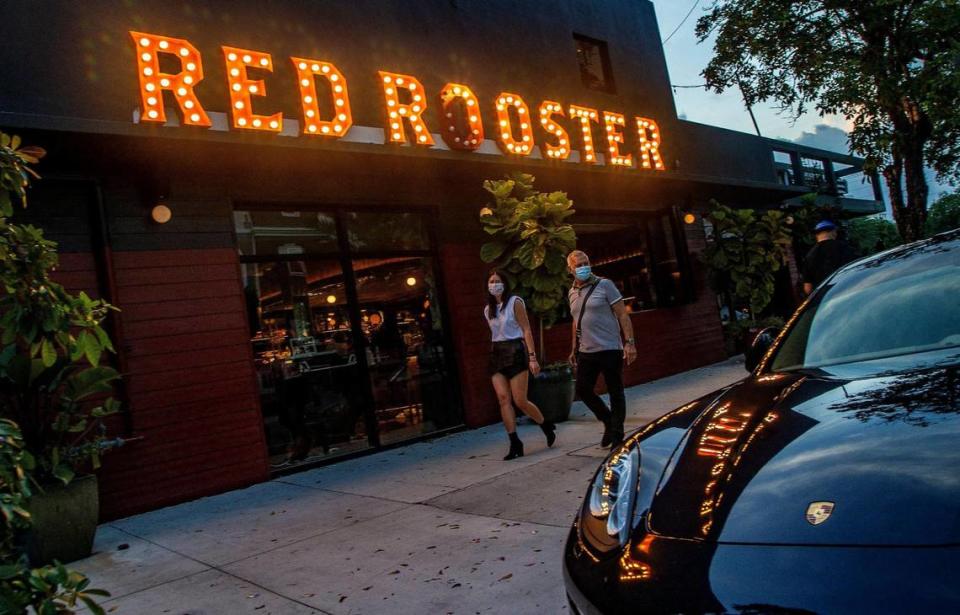 Joi Hwang and Bill Philipp walk by the Red Rooster restaurant in the heart of Miami’s Overtown neighborhood in April.