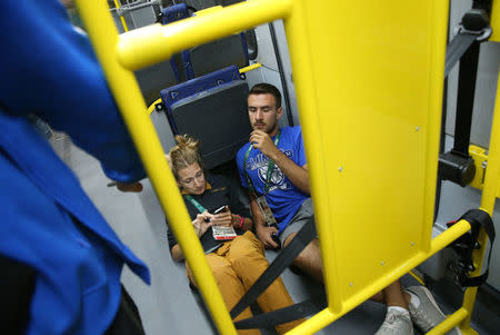 Technician Kaan Korkmaz (R) and journalist Joanna Moyse lie on the floor of an official media bus after a window shattered when driving accredited journalists to the Main Transport Mall from the Deodoro venue of the Rio 2016 Olympic Games in Rio de Janeiro, August 9, 2016. REUTERS/Shannon Stapleton