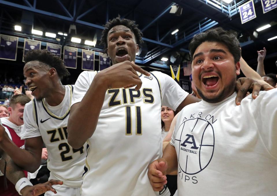 Akron Zips forward Sammy Hunter (11) and guard Ali Ali (24) celebrate with students after beating Kent State, Friday, Feb. 23, 2024.