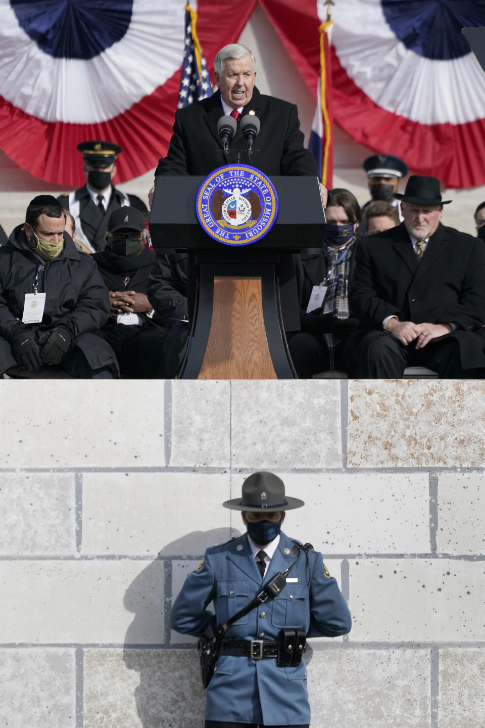Missouri Gov. Mike Parson delivers the inaugural address after being sworn in to his first full term as governor as a member of the Missouri Highway Patrol stands below Monday, Jan. 11, 2021, in Jefferson City, Mo. (AP Photo/Jeff Roberson)