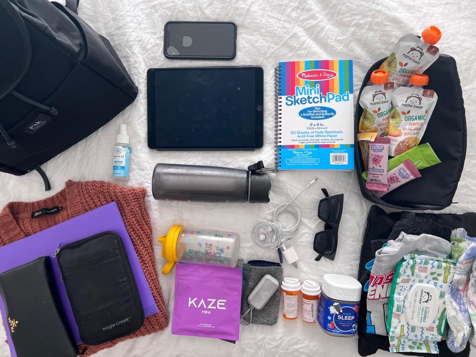 jordi's carry-on items laid out on bed