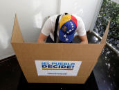 <p>A person votes during an unofficial plebiscite against Venezuela’s President Nicolas Maduro’s government, in Sao Paulo, Brazil July 16, 2017. (Paulo Whitaker/Reuters) </p>