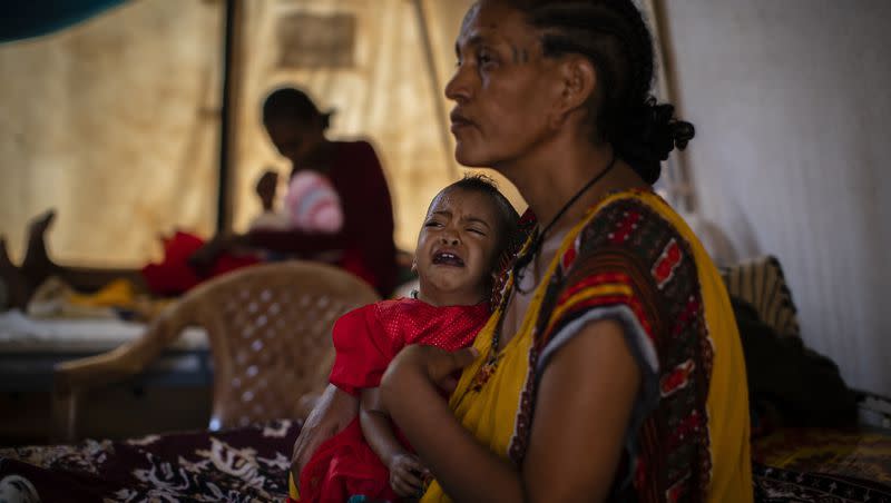 Roman Kidanemariam, 35, holds her malnourished daughter, Merkab Ataklti, 22 months old, in the treatment tent of a medical clinic in the town of Abi Adi, in the Tigray region of northern Ethiopia on May 11, 2021.