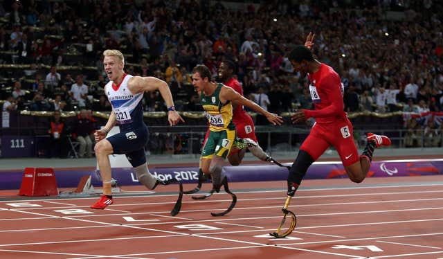 Jonnie Peacock, left, crosses the line