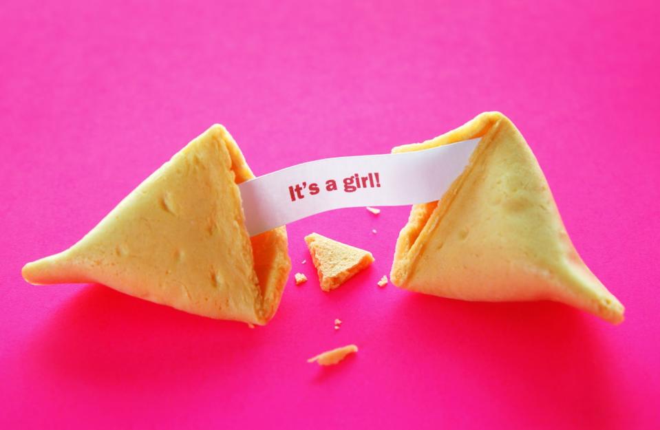 open fortune cookie with it's a girl on paper between two sides of cookie
