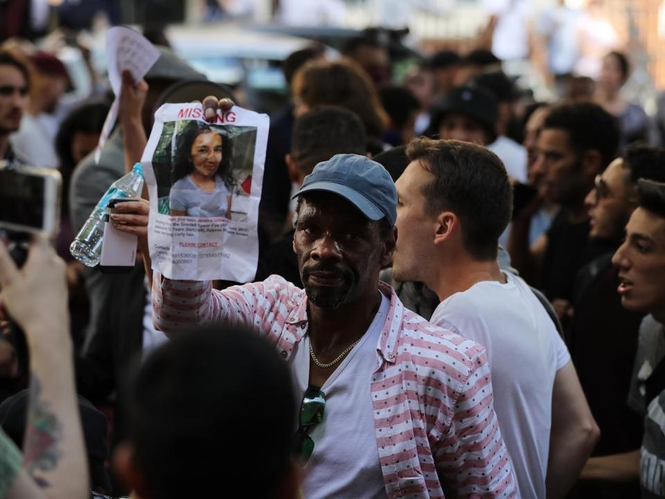 A man holds a sign for Jessica Urbano, missing since the fire (Getty)