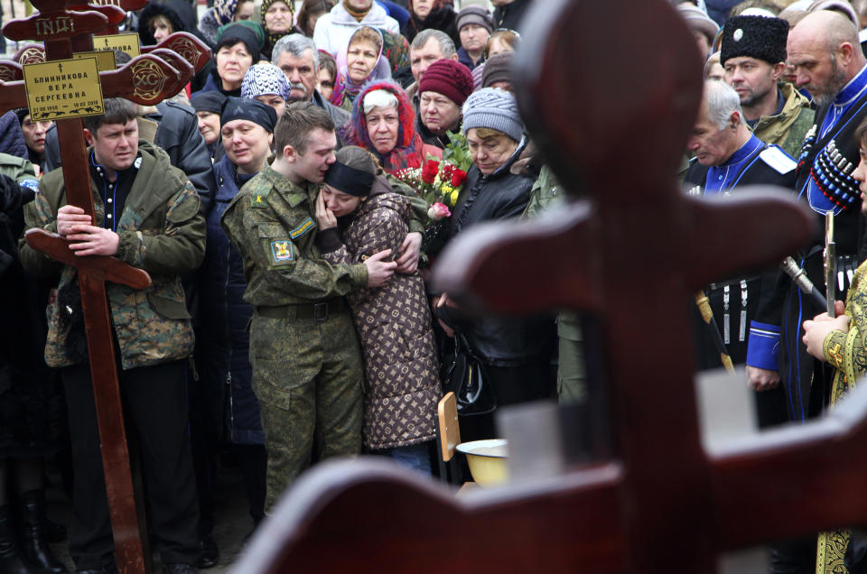 FILE - In this Tuesday, Feb. 20, 2018 file photo family and friends of victims of the deadly attack on churchgoers in Russia's predominantly Muslim Dagestan region, attend a funeral service in Kizlyar, Russia. At least five people were killed and four wounded when a gunman opened fire with a hunting rifles on people leaving a Sunday service at a Russian Orthodox church in the Dagestan city of Kizlyar. (AP Photo/Musa Sadulayev, File)