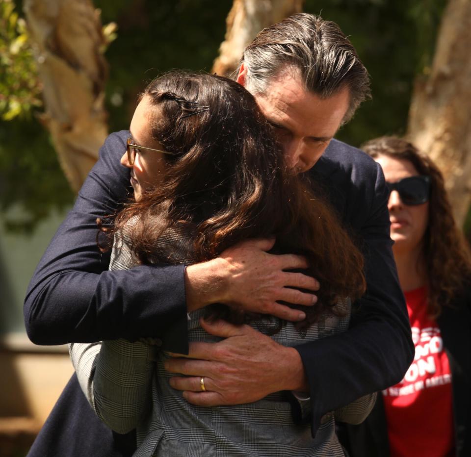 A man hugs a woman.