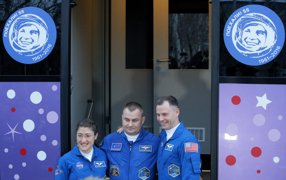 U.S. astronauts Christina Hammock Koch, left, Nick Hague, right, and Russian cosmonaut Alexey Ovchinin, members of the main crew to the International Space Station (ISS), pose near a bus prior to the launch of the Soyuz FG rocket at the Russian leased Baikonur cosmodrome, Kazakhstan, Wednesday, March 13, 2019. The new Soyuz mission to the International Space Station (ISS) is scheduled on Thursday, March. 14. (AP Photo/Dmitri Lovetsky)