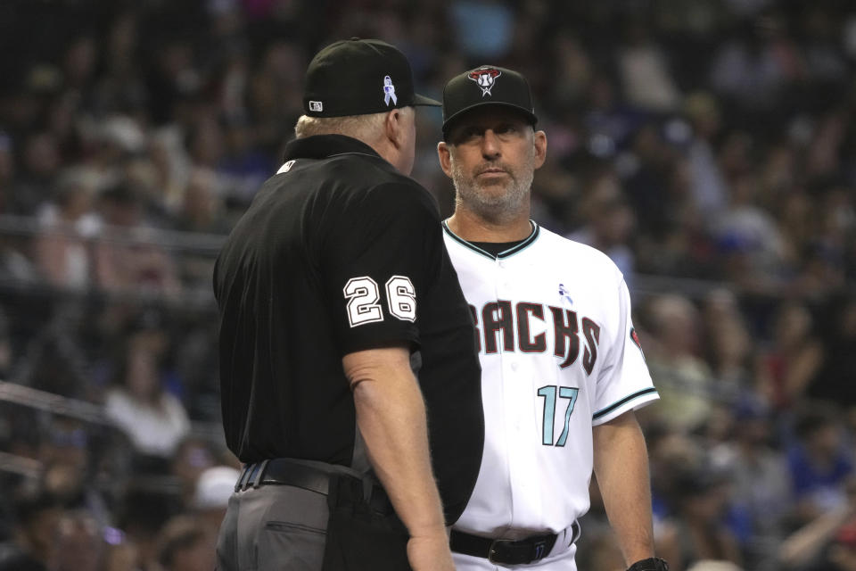 Arizona Diamondbacks manager Torey Lovullo (17) talks to MLB umpire Bill Miller in the sixth inning during a baseball game against the Los Angeles Dodgers, Sunday, June 20, 2021, in Phoenix. (AP Photo/Rick Scuteri)