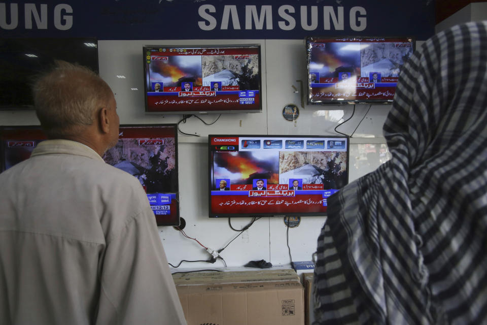 Pakistani watch news bulletins on television in Karachi, Pakistan, Wednesday, Feb. 27, 2019. Pakistan's air force shot down two Indian warplanes after they crossed the boundary between the two nuclear-armed rivals in the disputed territory of Kashmir on Wednesday and captured one Indian pilot, a military spokesman said. (AP Photo/Fareed Khan)