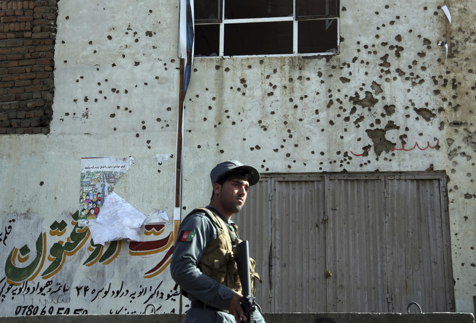 FILE - In this Oct. 29, 2018 file photo, an Afghan security personnel inspects the site of suicide attack near the election commission office in Kabul, Afghanistan. The United Nations Assistance Mission in Afghanistan said in a new report released Tuesday, Nov. 6, 2018, that 56 civilians were killed and 379 others wounded in attacks during the recent parliamentary election. The numbers reveal that more civilians were harmed in this year’s election violence than in four previous Afghanistan national elections. (AP Photo/Rahmat Gul, File)