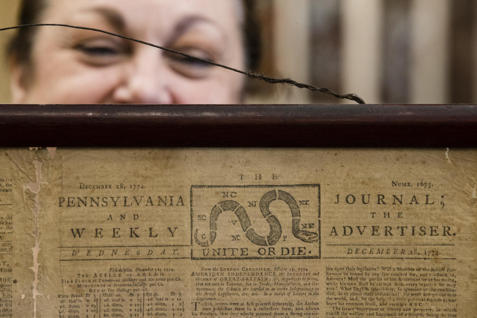 Heather Randall displays a Dec. 28, 1774 Pennsylvania Journal and the Weekly Advertiser at the Goodwill Industries in Bellmawr, N.J., Thursday, Oct. 25, 2018. A quick eye by Goodwill workers in southern New Jersey turned up an original 1774 Philadelphia newspaper with an iconic "Unite or Die" masthead. (AP Photo/Matt Rourke)