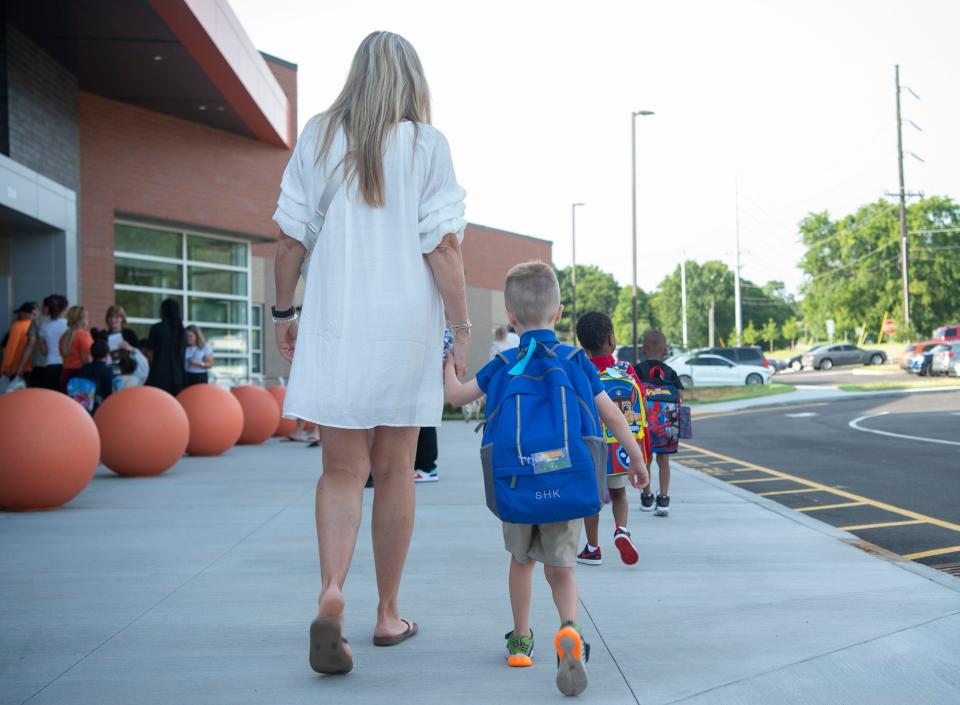 Kristen Sick helps walk a student into Goodlettsville Elementary School on the first day of classes on Aug. 8.