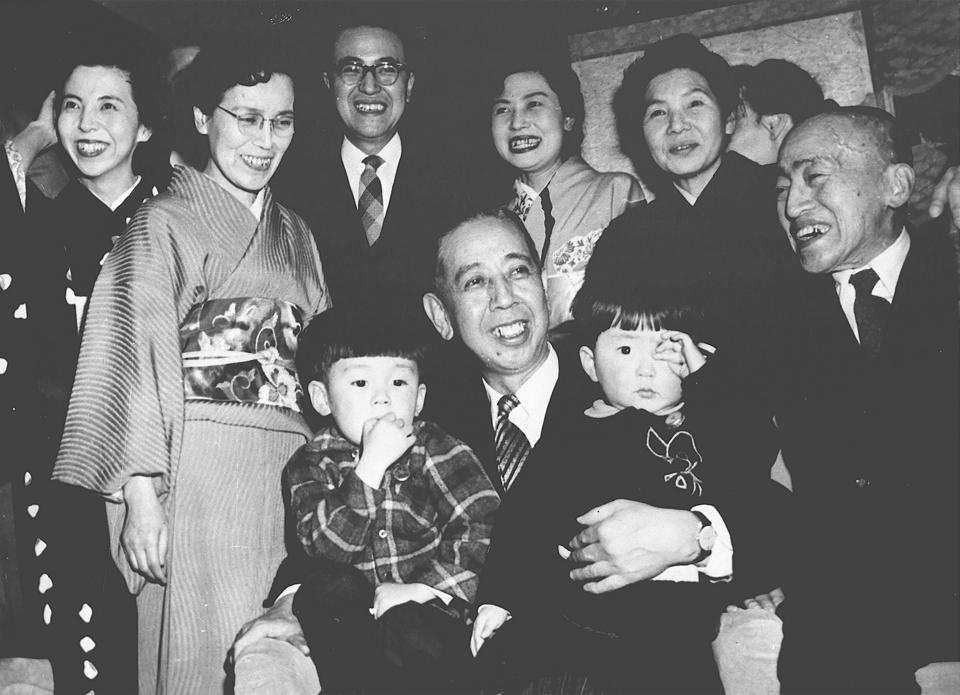 Shinzo Abe, front right, is held by his grandfather Nobusuke Kishi, front center, when Kishi was sworn in as new prime minister at an unknown place in Japan in February 1957. Japan’s longest-serving prime minister, Shinzo Abe was credited with instilling political and economic stability. However, he angered Japan’s neighbors South Korea and China along with many Japanese with his nationalistic rhetoric and calls to revise the country’s pacifist constitution. (Kyodo News via AP)