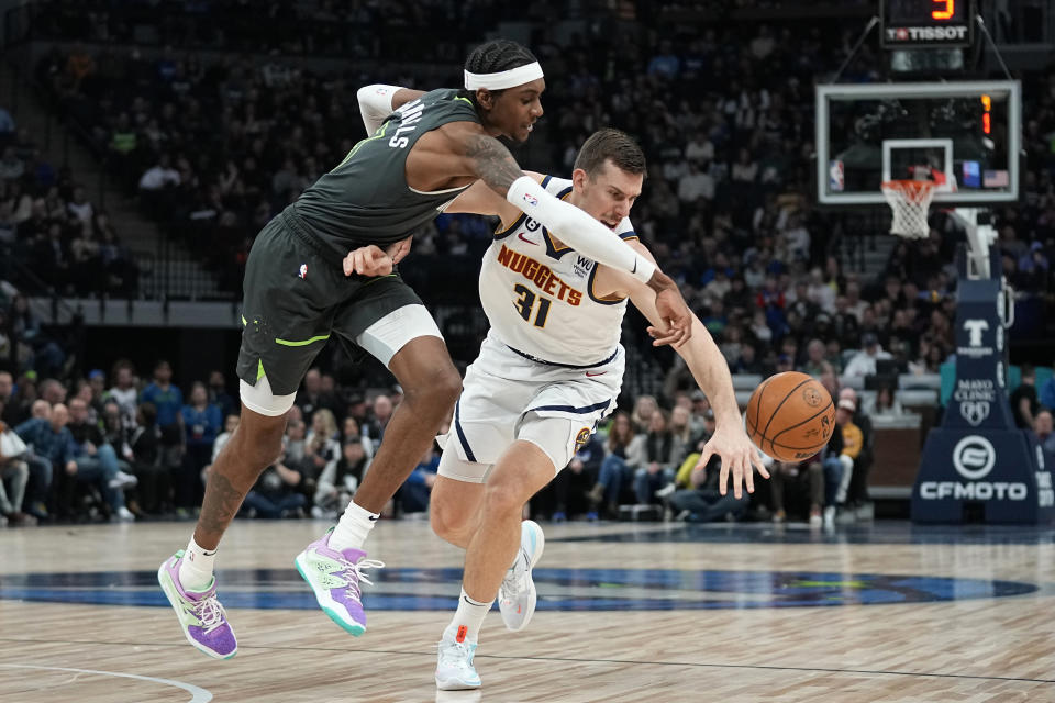 Denver Nuggets forward Vlatko Cancar (31), right, and Minnesota Timberwolves forward Jaden McDaniels battle for a loose ball during the second half of an NBA basketball game, Sunday, Feb. 5, 2023, in Minneapolis. (AP Photo/Abbie Parr)