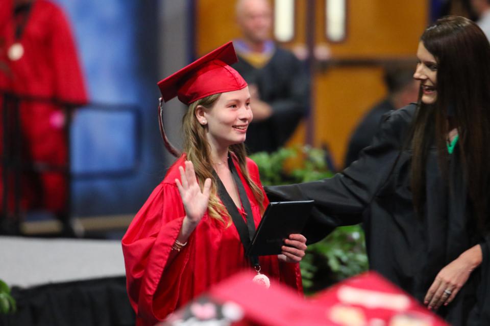 A newly minted Creekside High graduate waves to the crowd Saturday, May 28, 2022, at UNF Arena in Jacksonville.