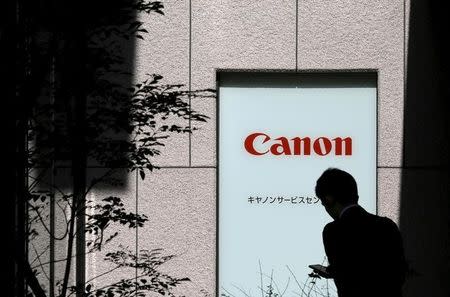 A man walks past a Canon logo in Tokyo, Japan, October 27, 2015. REUTERS/Toru Hanai