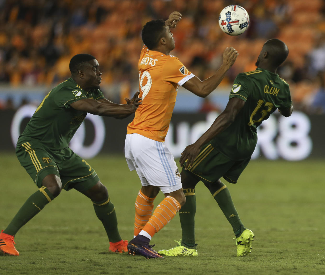 Houston Dynamo forward Mauro Manotas (19) battles with Portland Timbers players Larrys Mabiala (33) and Lawrence Olum (13) for possession of the ball during the MLS Western Conference semifinal soccer match Monday, Oct. 30, 2017, in Houston. (Yi-Chin Lee/Houston Chronicle via AP)