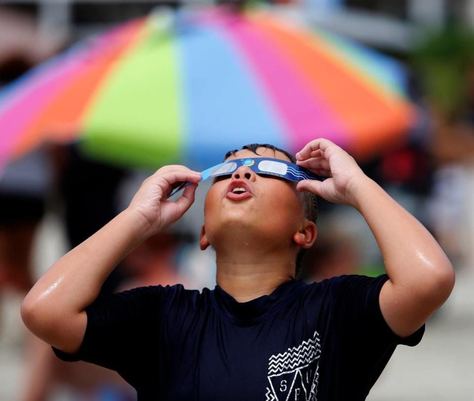 Ezra Packham, of Jacksonville, Fla., looks through his solar glasses in preparation for the solar eclipse Monday, Aug. 21, 2017, on the beach at Isle of Palms, S.C. Ezra and his family said the wanted to come to the Isle of Palms because they wanted to be on the beach and the city of Isle of Palms was giving away solar glasses.