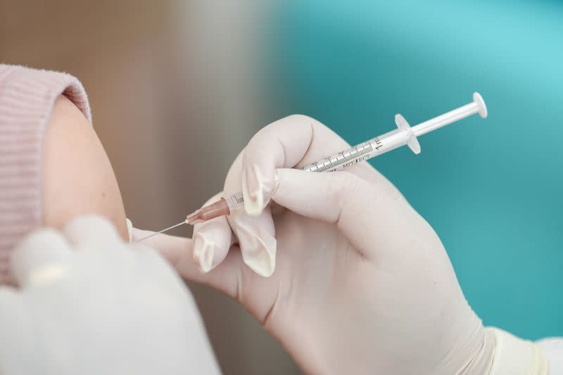 FILE PHOTO: A woman receives a booster dose of Pfizer-BioNTech vaccine against the coronavirus disease (COVID-19) at the Police hospital in Bangkok