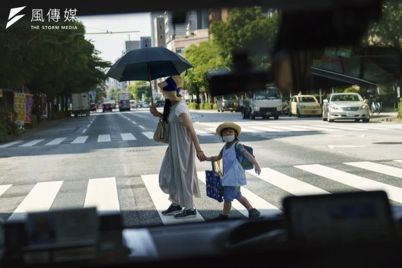 <cite>東京一位媽媽牽著孩子過馬路。（資料照，美聯社）</cite>