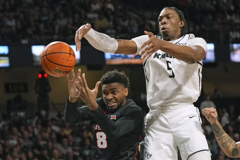 Central Florida forward Omar Payne (5) and Houston guard Mylik Wilson (8) reach for a rebound during the second half of an NCAA college basketball game Wednesday, March 6, 2024, in Orlando, Fla. (AP Photo/John Raoux)