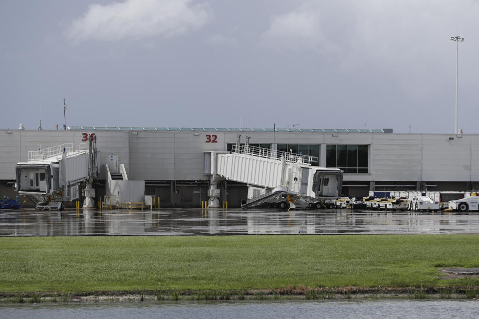 Boarding terminals remain empty with equipment idle at Orlando International Airport that was closed due to the anticipated arrival of Hurricane Dorian on the East Coast Tuesday, Sept. 3, 2019, in Orlando, Fla. (AP Photo/John Raoux)