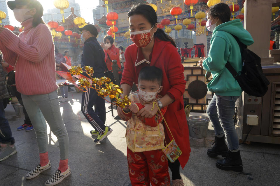 Worshippers wearing face masks to protect against the spread of the coronavirus, pray at the Wong Tai Sin Temple, in Hong Kong, Friday, Feb. 12, 2021, to celebrate the Lunar New Year which marks the Year of the Ox in the Chinese zodiac. (AP Photo/Kin Cheung)