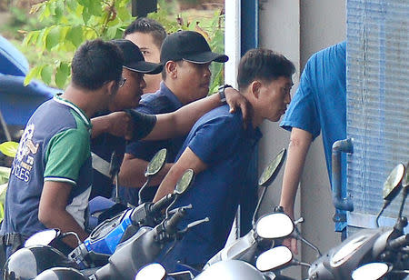 A North Korean man (R) identified by the Malaysian police as Ri Jong Chol and suspected by the authorities to be in connection with the murder of Kim Jong Nam, is taken to a police station in Sepang, Malaysia, February 18, 2017. Park Jung-ho/News1 via REUTERS