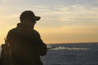 In this image provided by the U.S. Navy, Cmdr. Brad A. Fancher, commanding officer of the dock landing ship USS Carter Hall (LSD 50), observes the debris field of a high-altitude surveillance balloon Saturday, Feb. 4 2023, off the coast of South Carolina. Carter Hall is the lead ship in debris recovery efforts led by the Navy. (Jerry Ireland/U.S. Navy via AP)